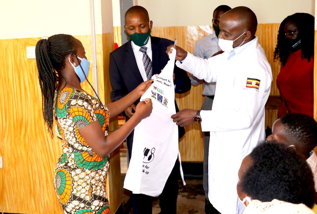 The Coordinator Dr. Geofrey Musinguzi hands over an apron with IEC messages as part of the items donated by the SPICES Uganda Project, MakSPH to Misindye-Goma HCIII in Mukono District, Uganda on 20th August 2020. The support will boost the facility's efforts to deal with COVID-19 and CVDs.